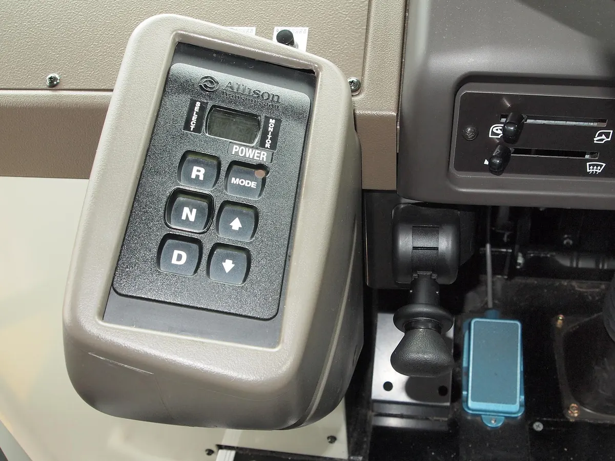 Close-up of an Allison commercial automatic push-button transmission shift selector with R, N, D buttons and parking brake valve