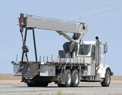 White flatbed boom truck with a folded crane