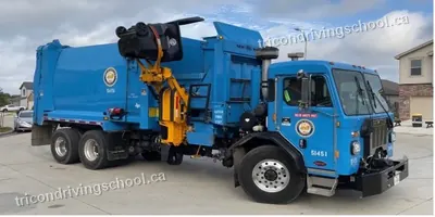 Blue automated side-loader garbage truck with a lifting arm