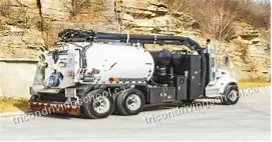 White hydrovac excavation truck parked by a rock face