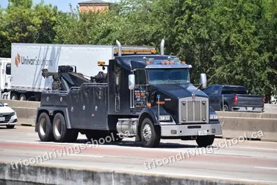 Heavy-duty tow truck driving on a highway