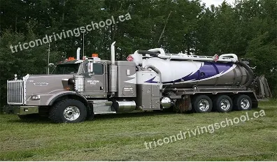 Vacuum tank truck parked on grass