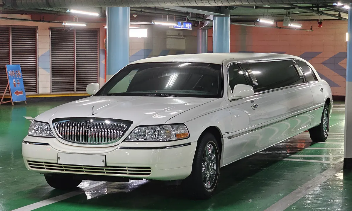 White stretch limousine, a Lincoln Town Car, parked in an indoor car park
