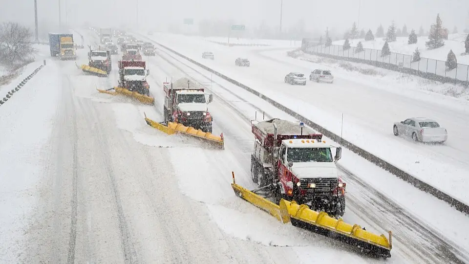 City snowplough trucks clearing a highway