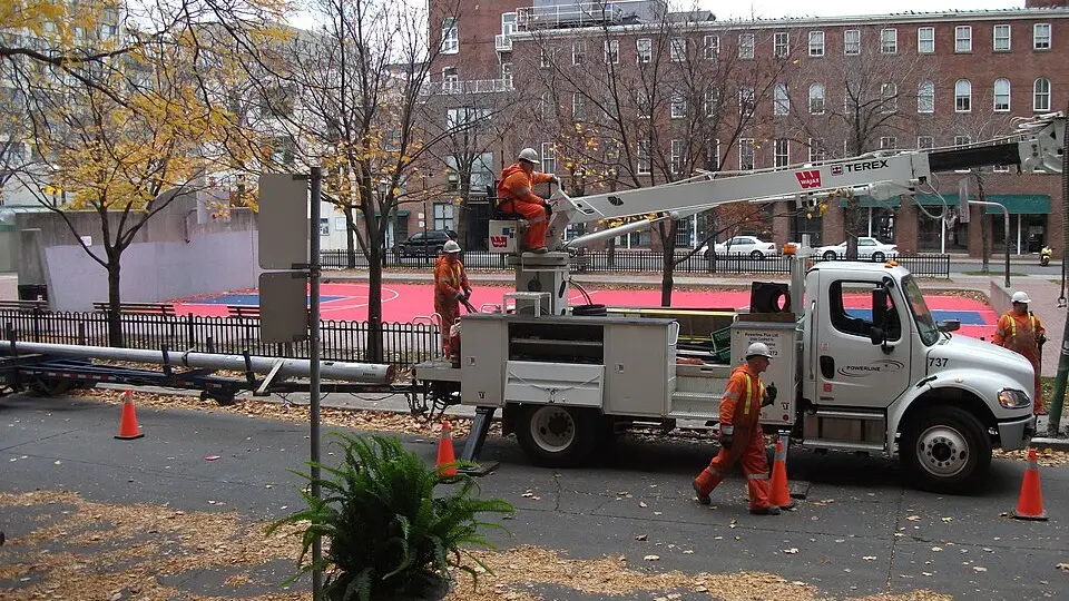 A utility bucket truck with a crew working overhead